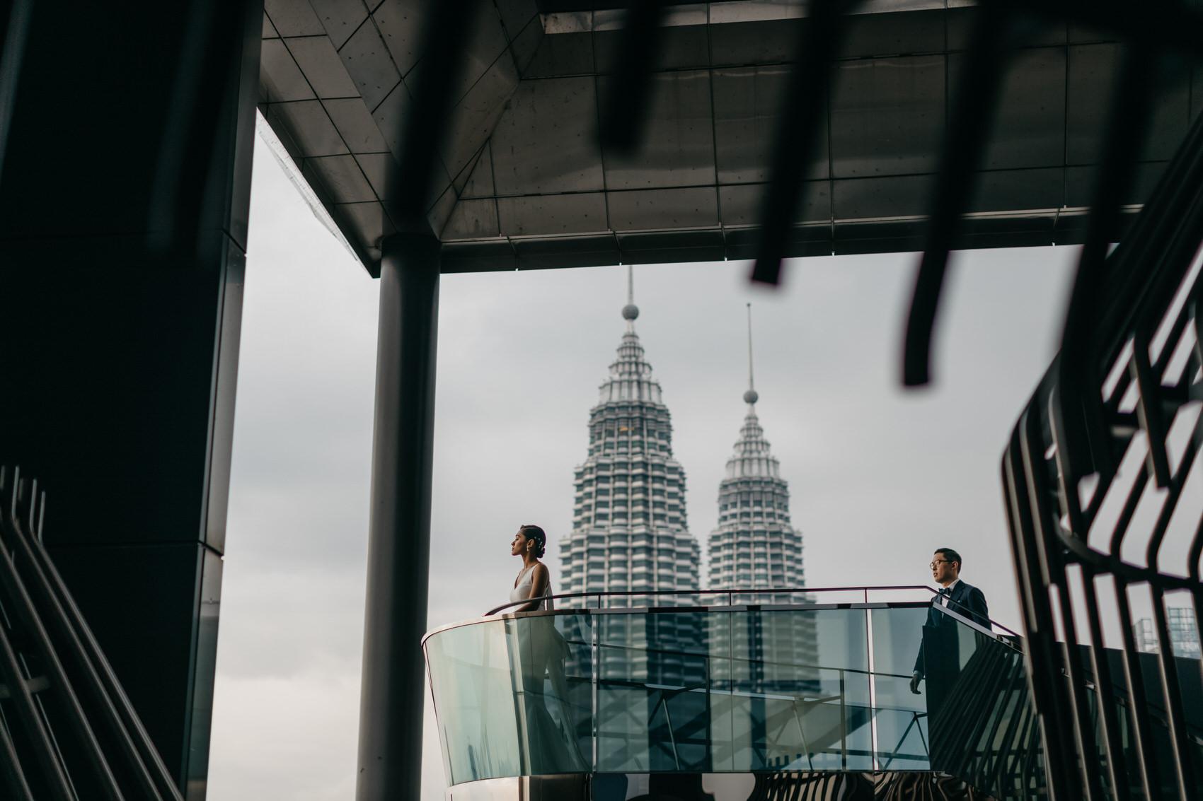Couple portrait on the rooftop of EQ Hotel KL. Skyline with KLCC as a backdrop. A dreamy and romantic, moon-themed wedding reception at The Equatorial Hotel Kuala Lumpur. Liyana and Carlos's love shone bright like the moon at this magical venue.