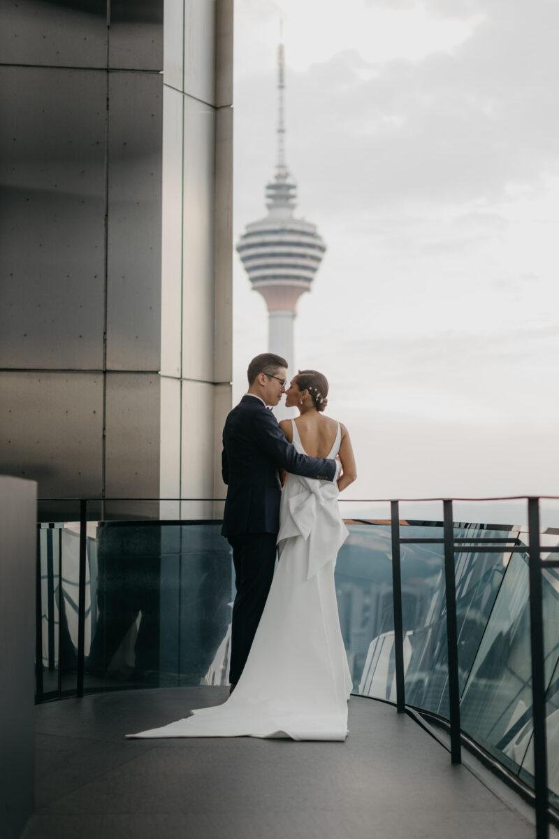 bride and groom photos on the rooftop of EQ Hotel Kuala Lumpur with KL tower as a backdrop. A dreamy and romantic, moon-themed wedding reception on the famous rooftop of The Equatorial Hotel Kuala Lumpur. Liyana and Carlos's love shone bright like the moon at this magical venue.