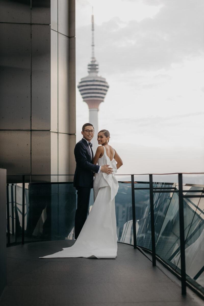 bride and groom photos on the rooftop of EQ Hotel Kuala Lumpur with KL tower as a backdrop. A dreamy and romantic, moon-themed wedding reception on the famous rooftop of The Equatorial Hotel Kuala Lumpur. Liyana and Carlos's love shone bright like the moon at this magical venue.