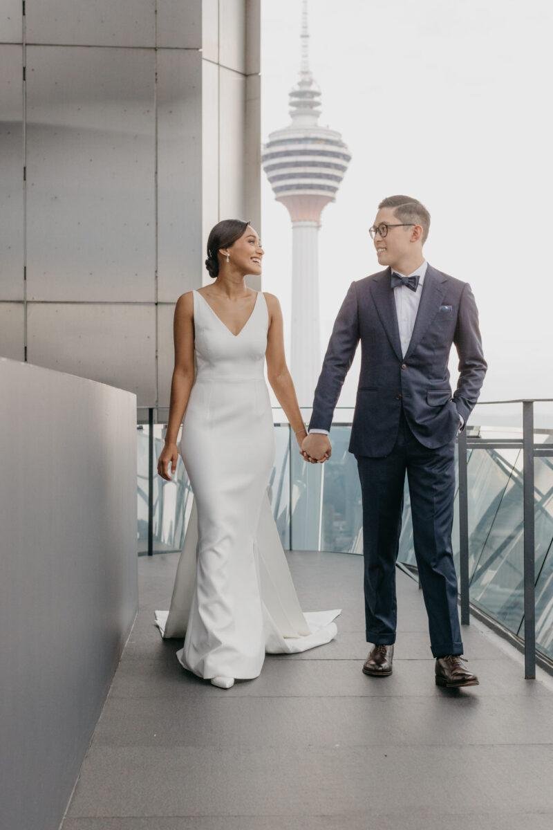 bride and groom photos on the rooftop of EQ Hotel Kuala Lumpur with KL tower as a backdrop. A dreamy and romantic, moon-themed wedding reception on the famous rooftop of The Equatorial Hotel Kuala Lumpur. Liyana and Carlos's love shone bright like the moon at this magical venue.