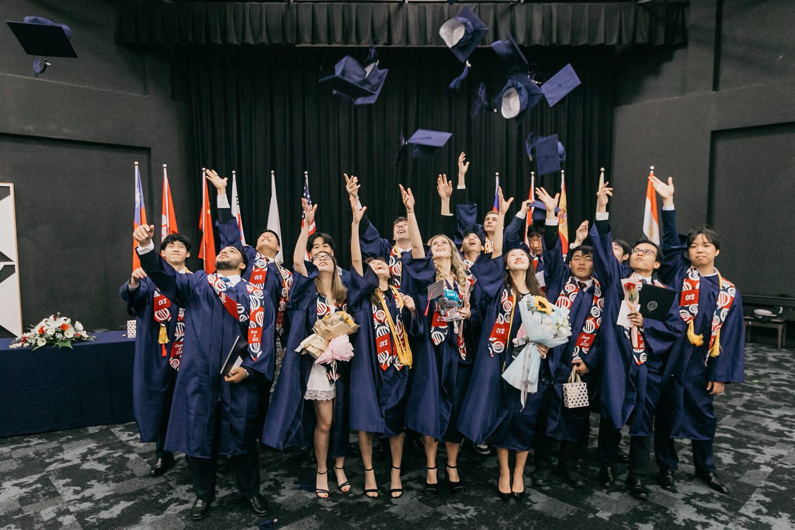 A festive celebration with confetti and cheers, congratulating the graduates of Oasis International School 2023 on their remarkable achievement.