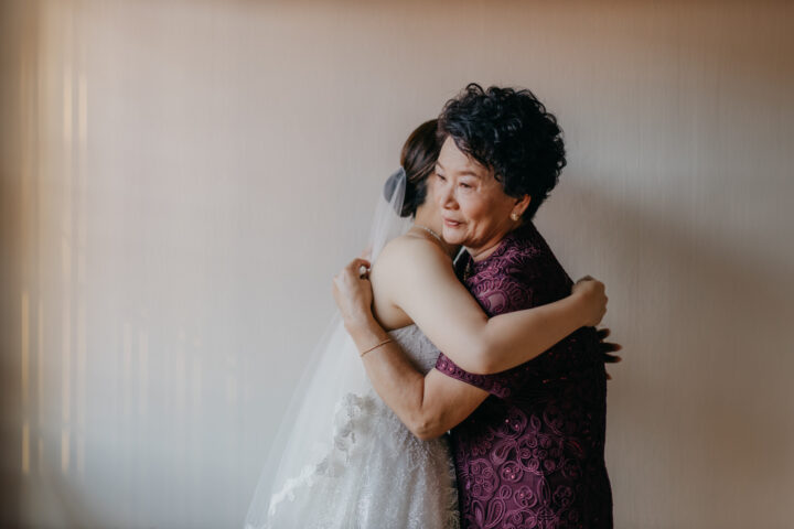 Loving mother embracing bride in a heartwarming wedding.
