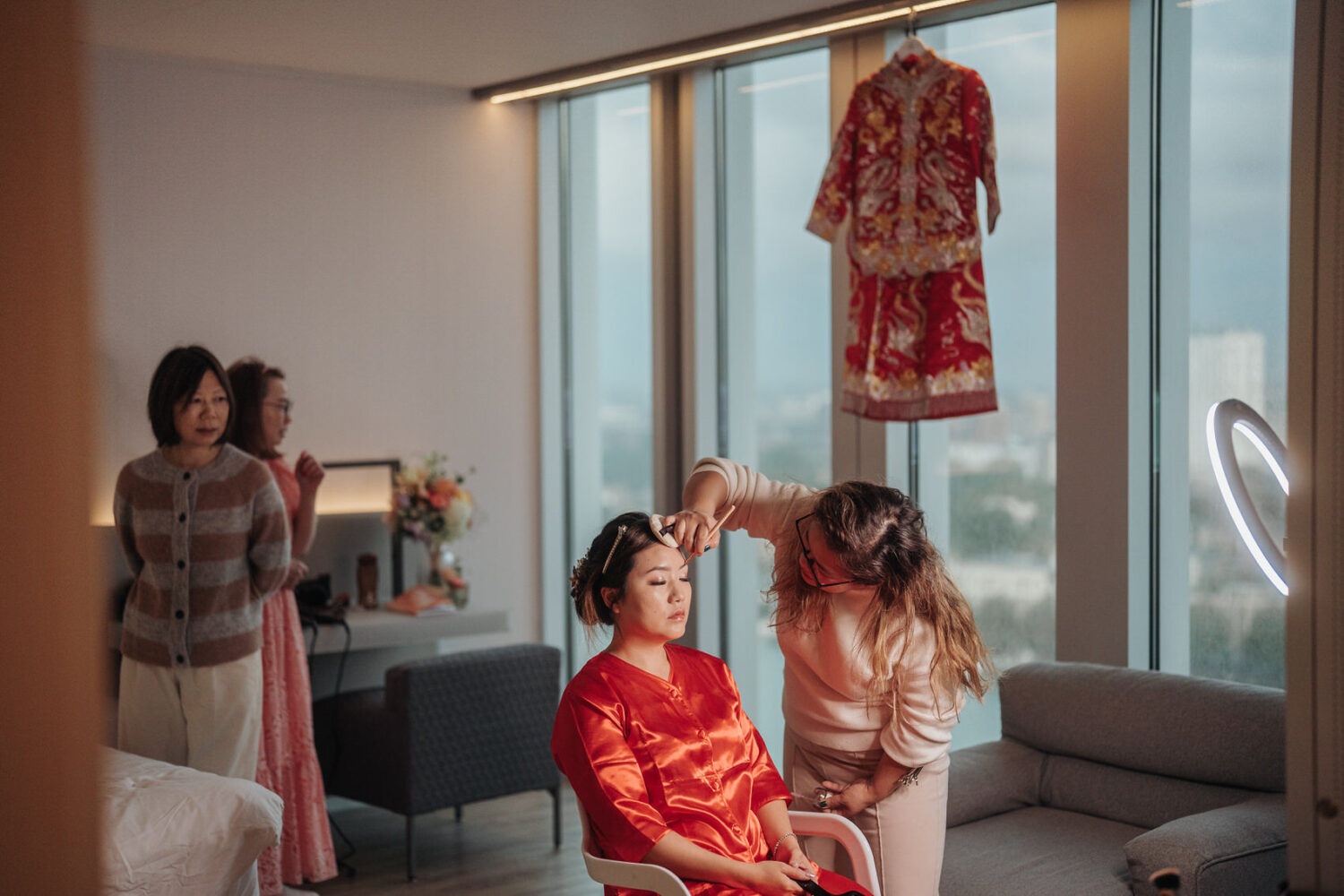 Bride getting ready in traditional Chinese attire at NHow Hotel in Rotterdam. A Destination Wedding Photography in Rotterdam | Jukki & Robin