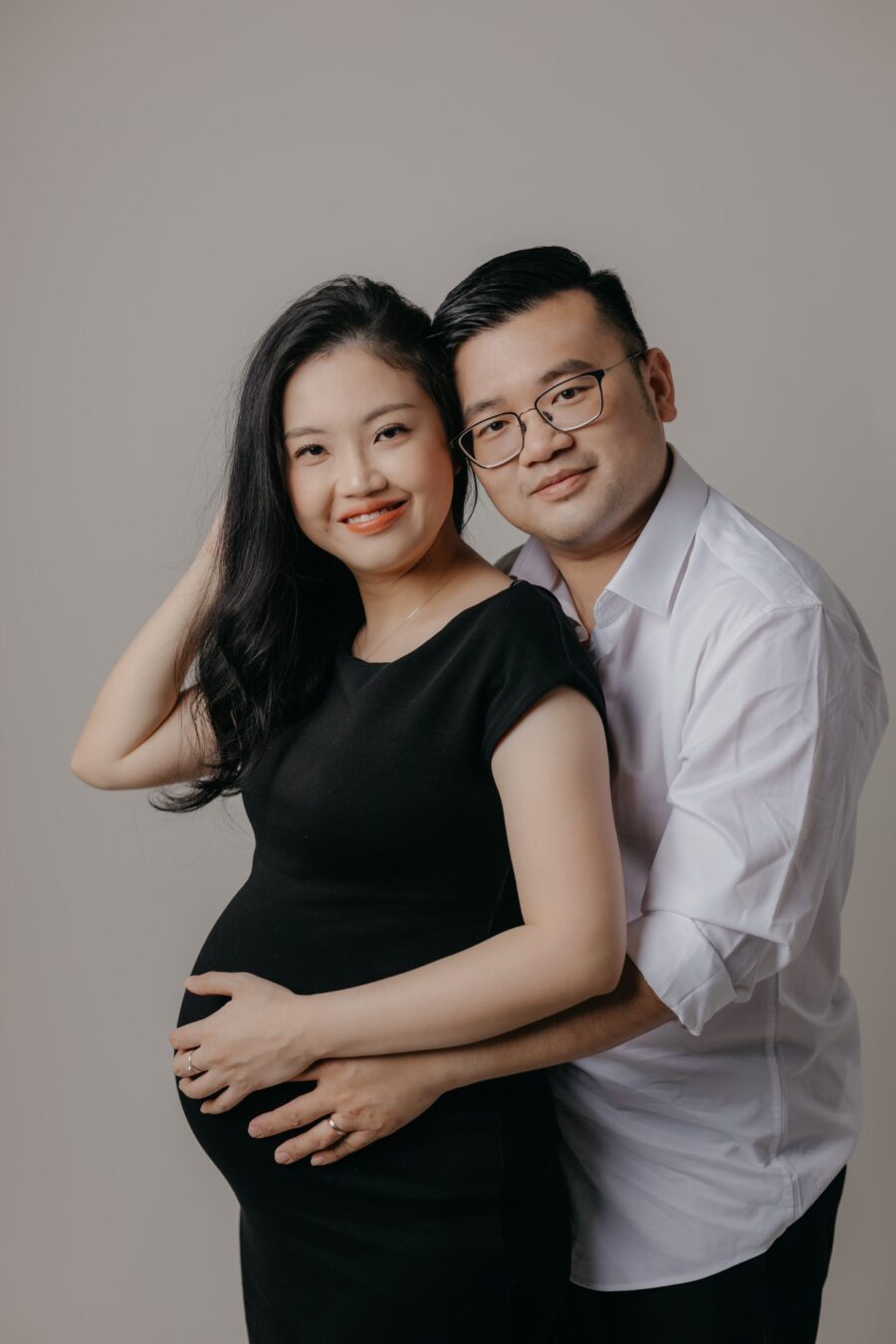 Expectant parents embracing during mini maternity session at Darkroom Project Studio