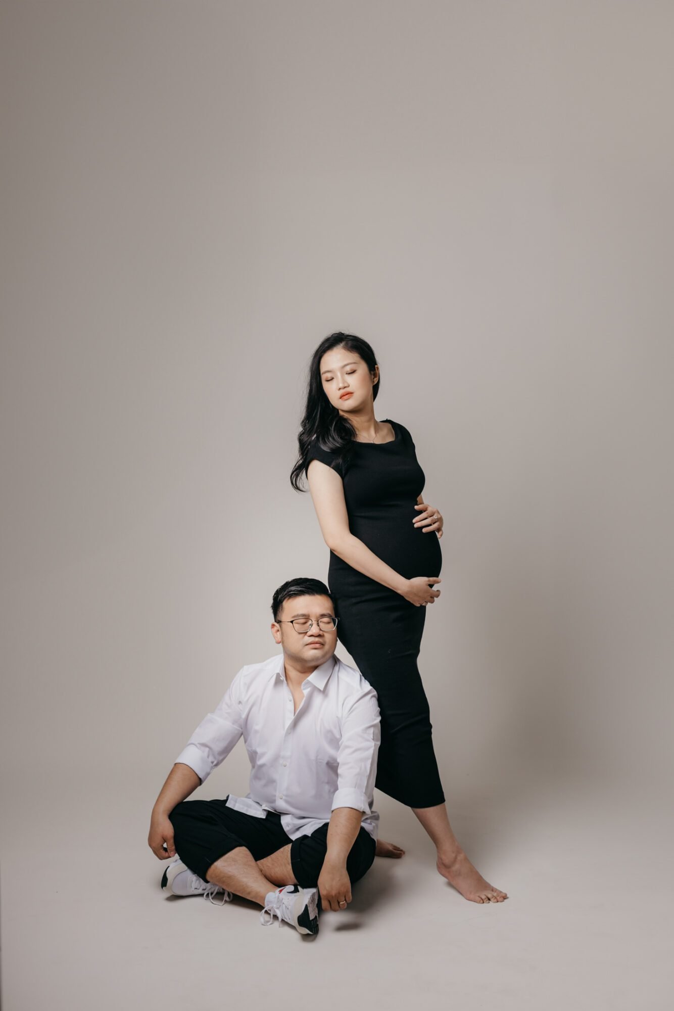 Expectant parents embracing during mini maternity session at Darkroom Project Studio