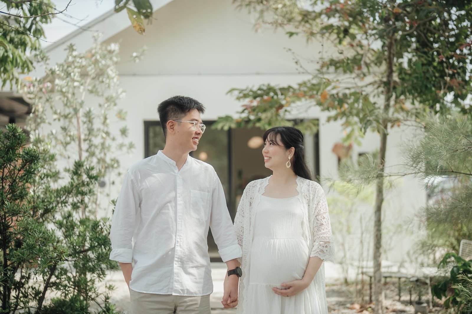 Joyful couple smiling during outdoor maternity photoshoot