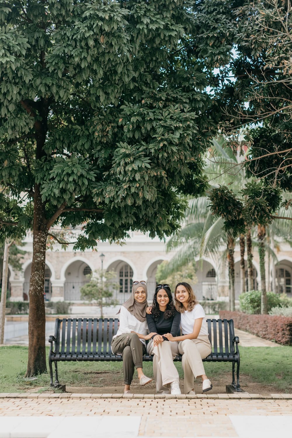 Raidah family photo session in Kuala Lumpur on bench at Sultan Abdul Samad Building
