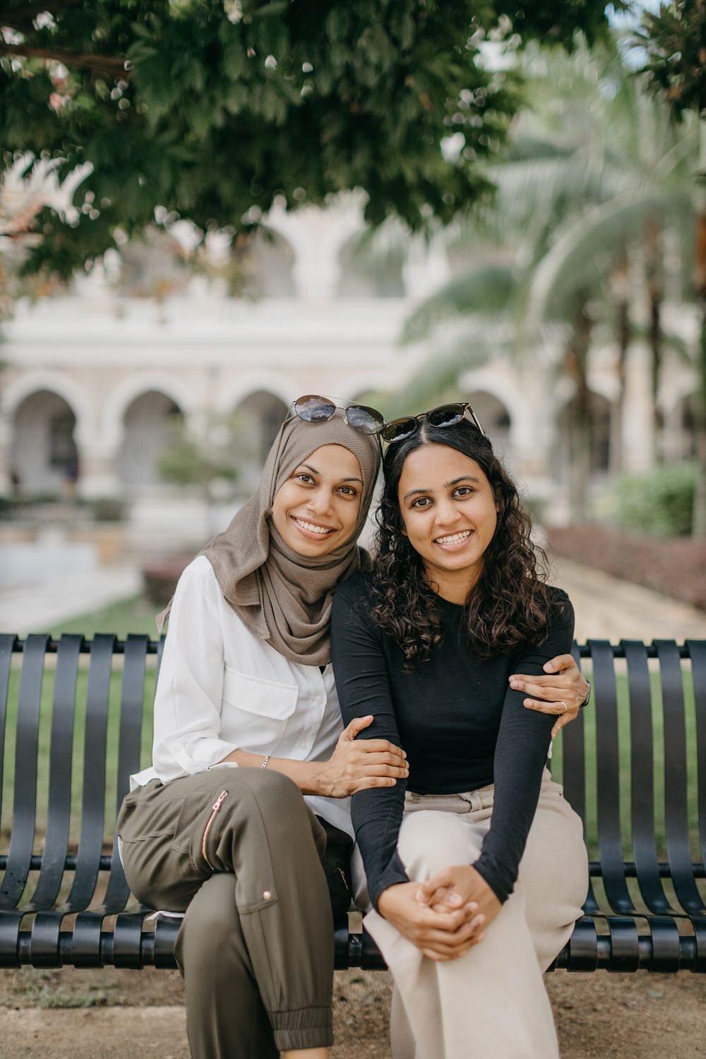 Raidah family photo session in Kuala Lumpur on bench at Sultan Abdul Samad Building