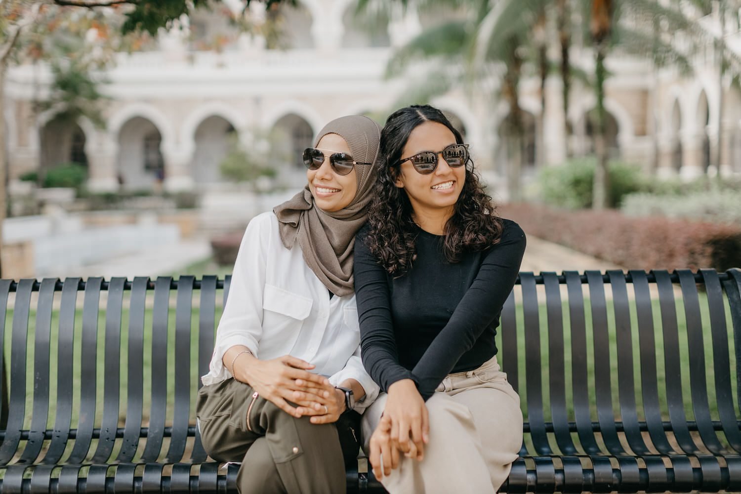 Raidah family photo session in Kuala Lumpur on bench at Sultan Abdul Samad Building