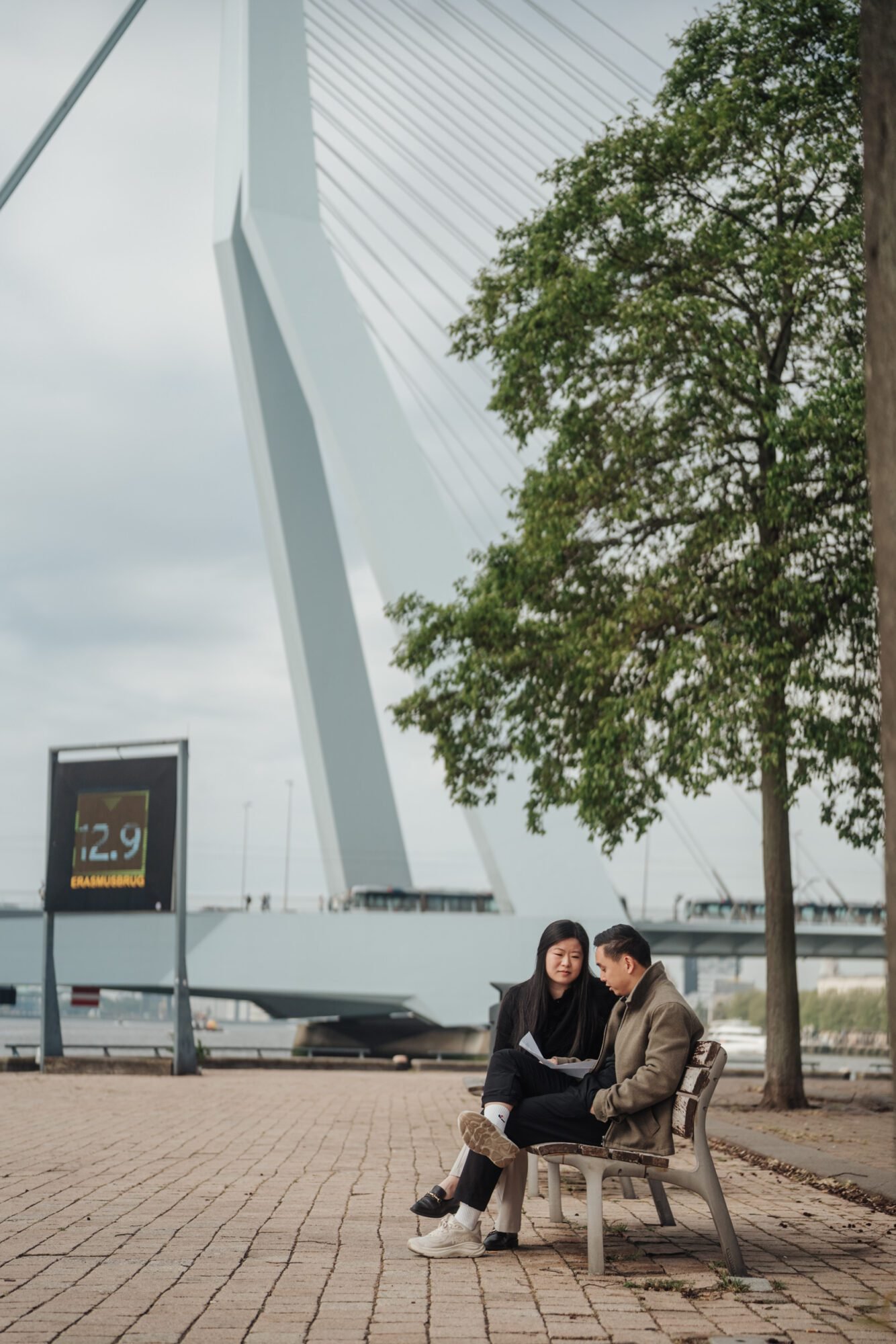 Couple sitting together near Rotterdam’s Erasmus Bridge