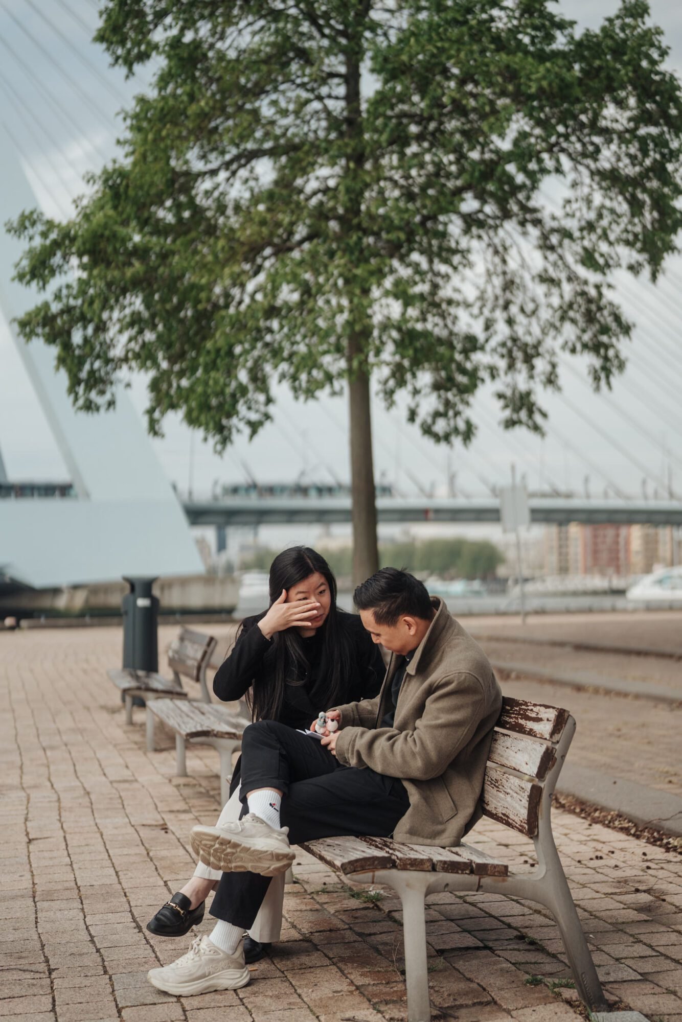 Couple sitting together near Rotterdam’s Erasmus Bridge