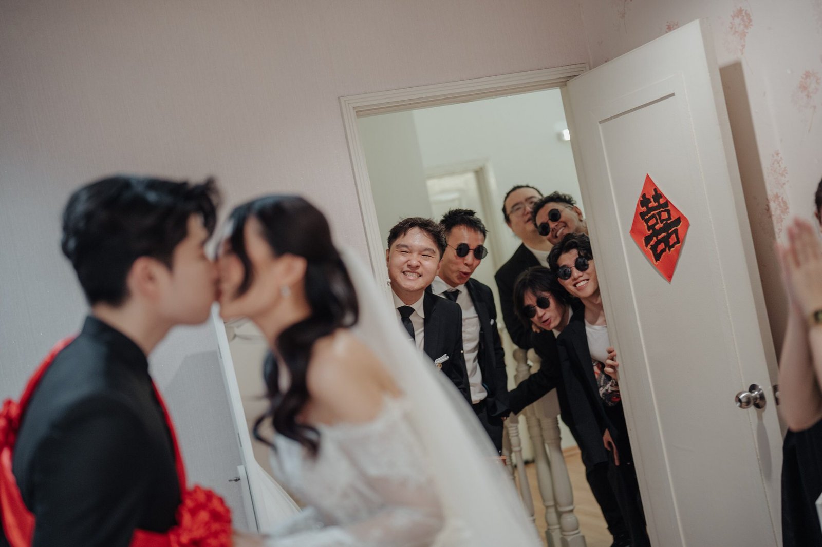 Groomsmen playfully watching Silver and Yi Shien share a kiss